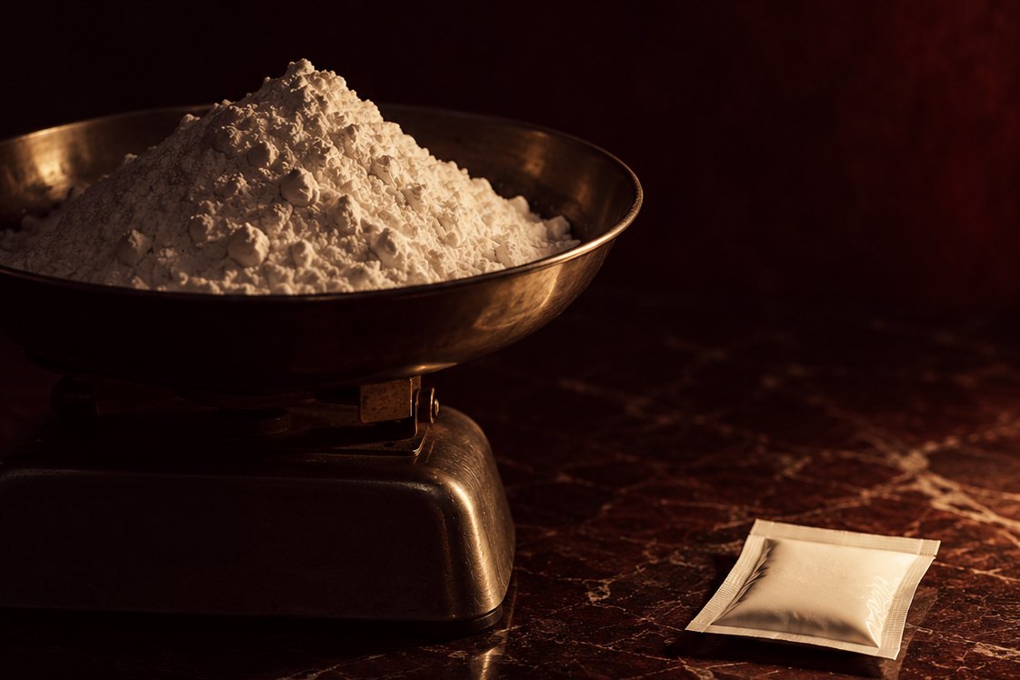 Un mucchio di polvere su una bilancia accanto a una sola bustina: nel collagene conta quale peptide, non solo quanti grammi